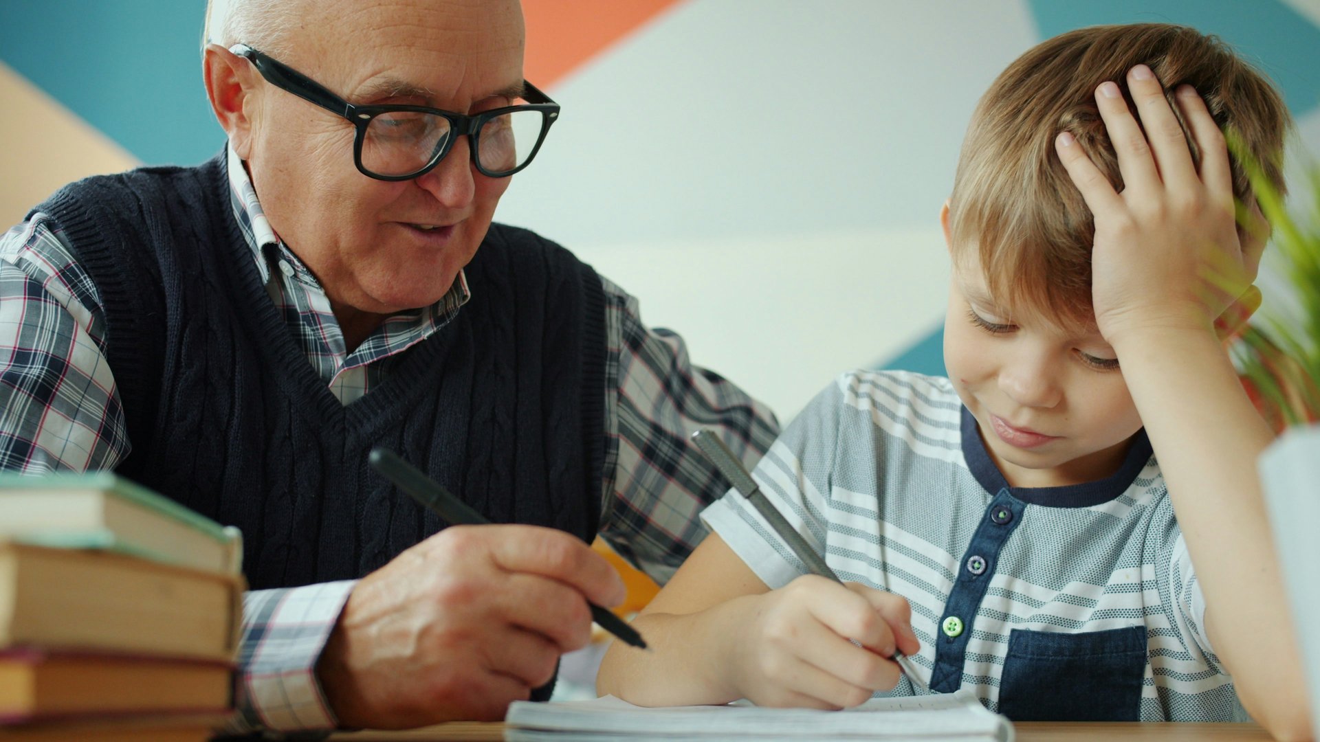 An adult helping a child with homework at a table