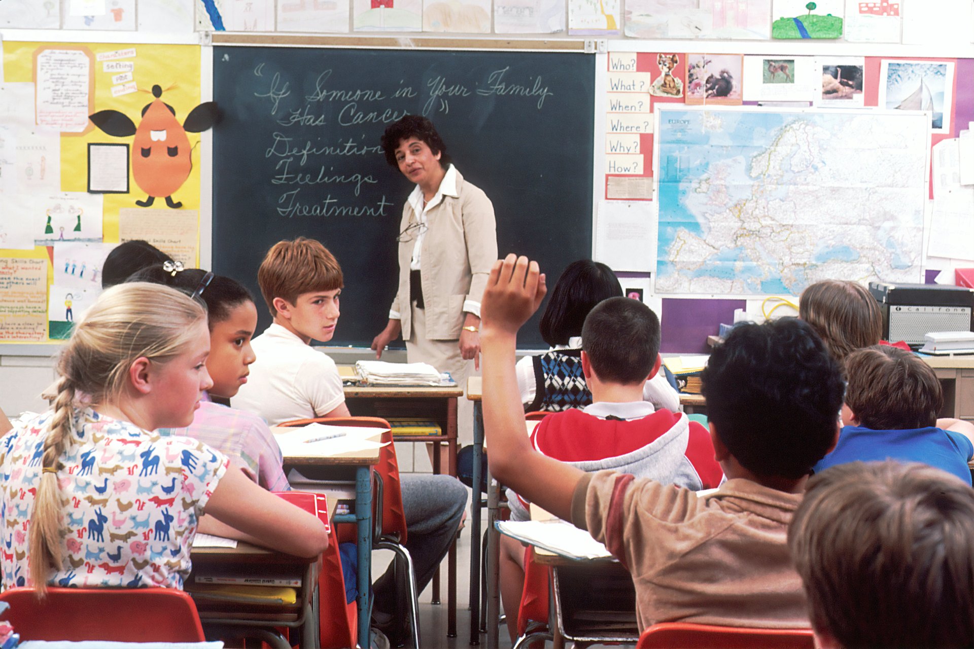 Hispanic student raising hand in class
