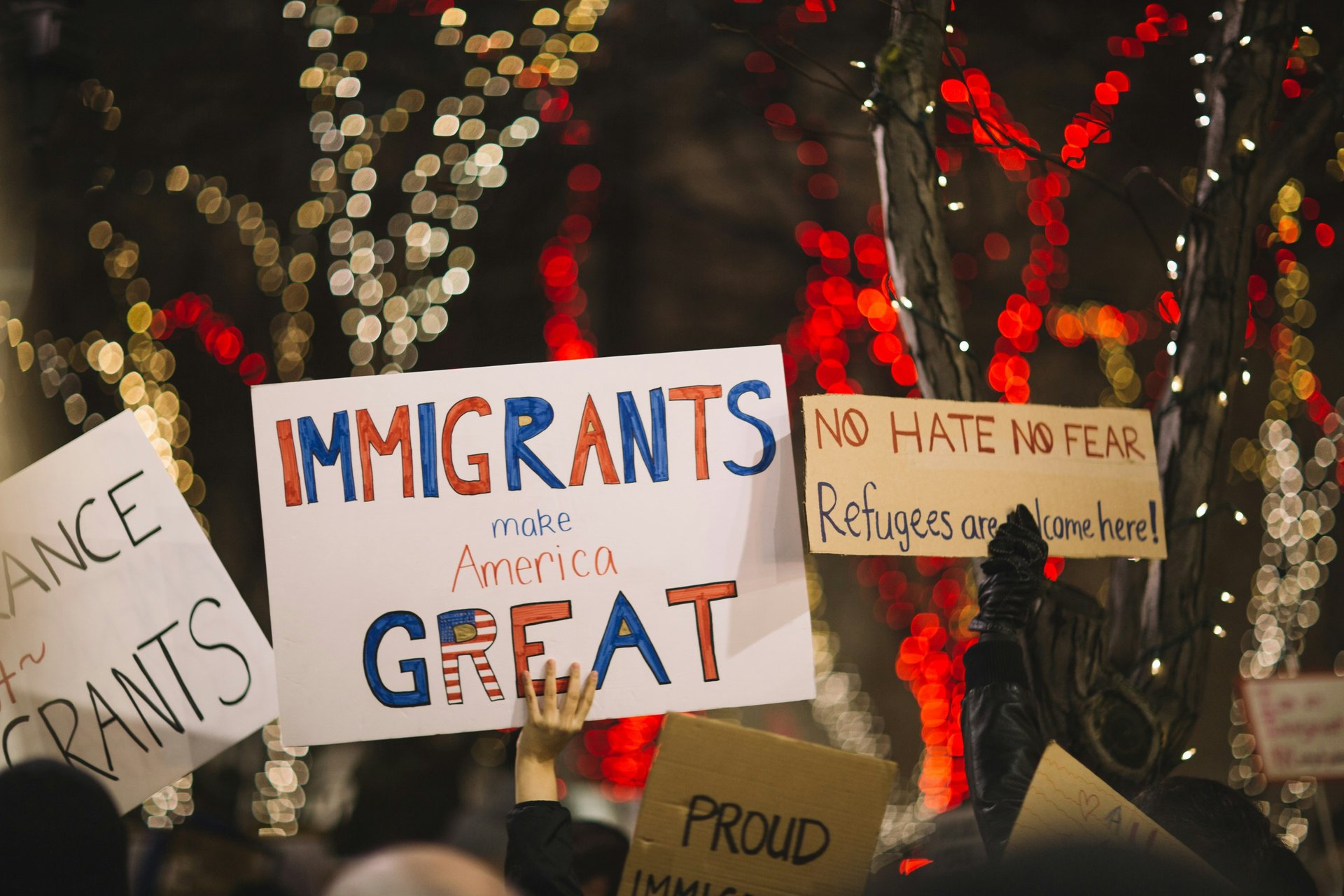 Person holding a sign reading Immigrants Make America Great