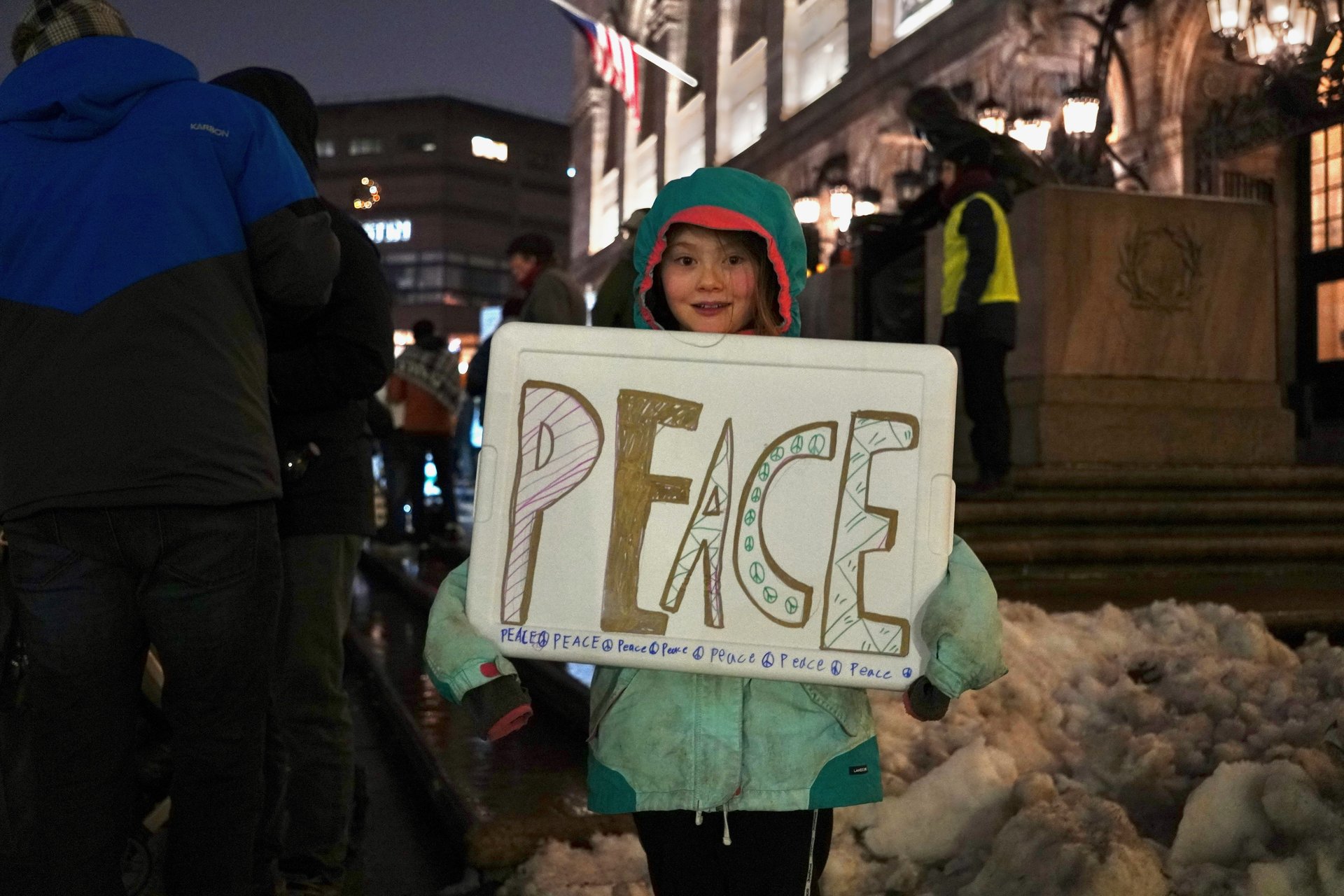 Young child holding a peace sign at a demonstration